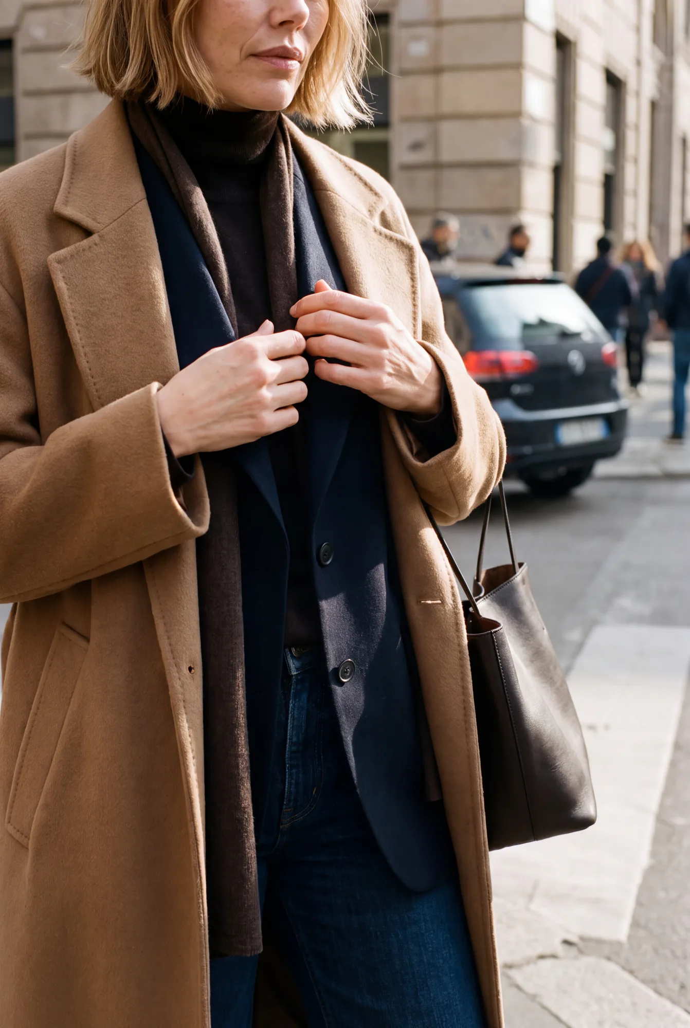 Margot on a crisp cold-weather commute in Milan, a detail crop of her hands at the collar, hair reparted. The navy | The Quiet Shoulder, Relover
